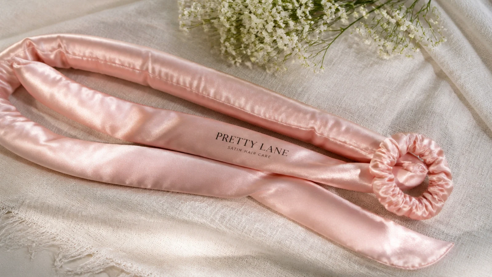 Faceless flat lay of a satin curling robe sash used for heatless robe curls