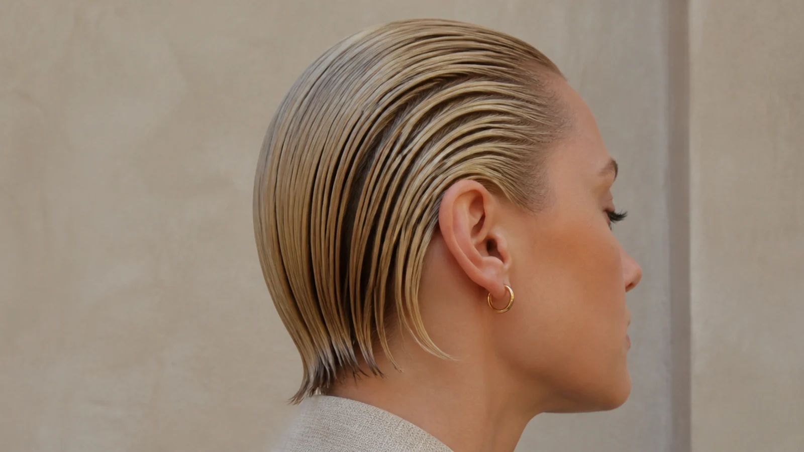 Faceless side view of short fine hair slicked straight back in a glossy wet-look finish