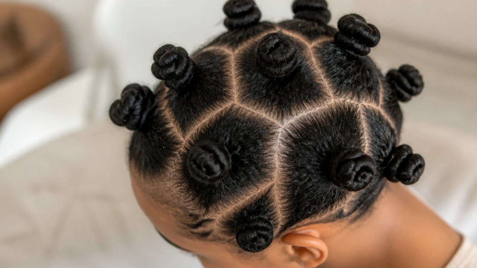 Faceless top view of neatly coiled bantu knots on fine 4C hair with loose, even sections