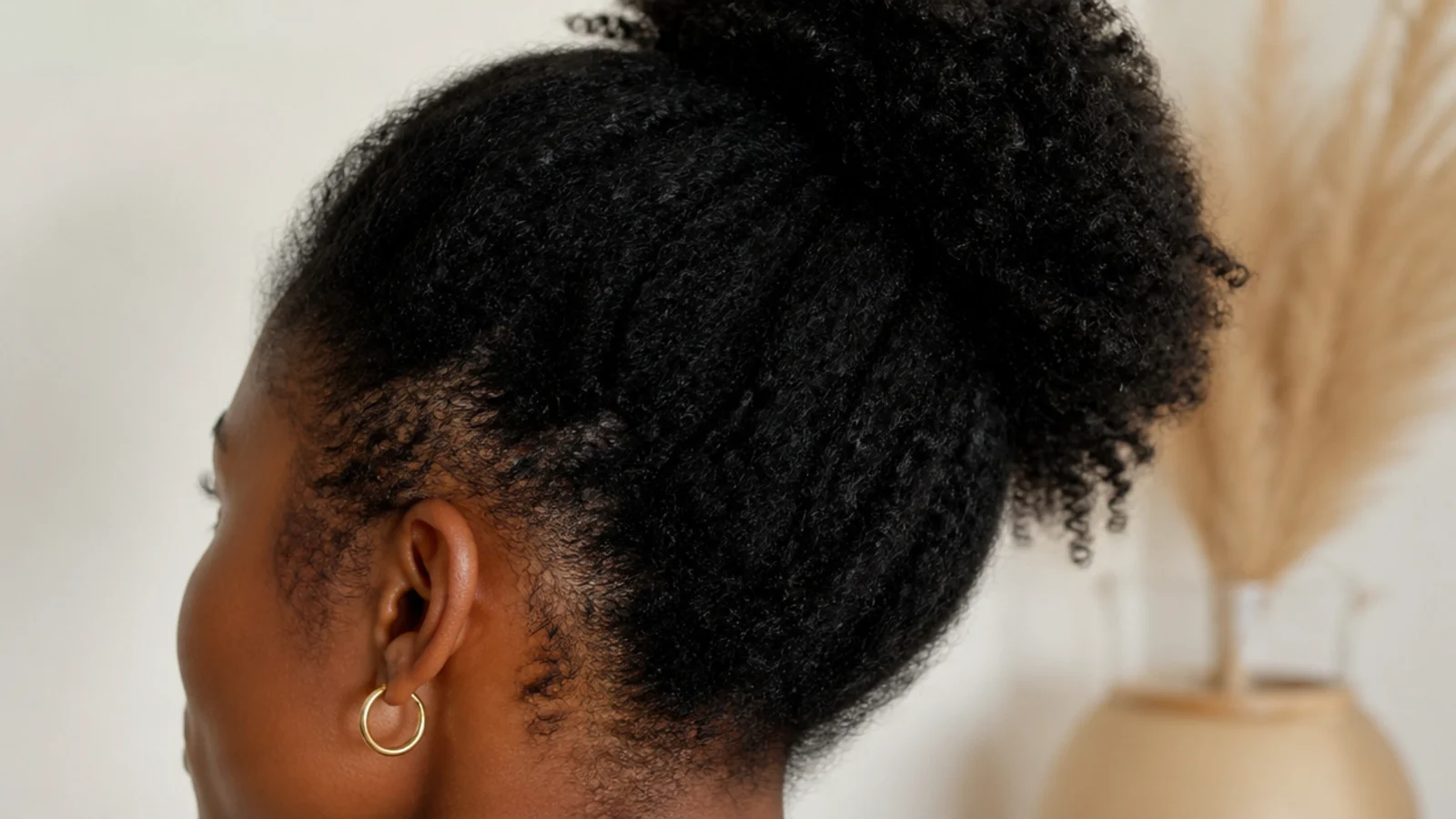 Faceless close-up of a soft, intact fine 4C hairline left loose at the temples instead of braided tight