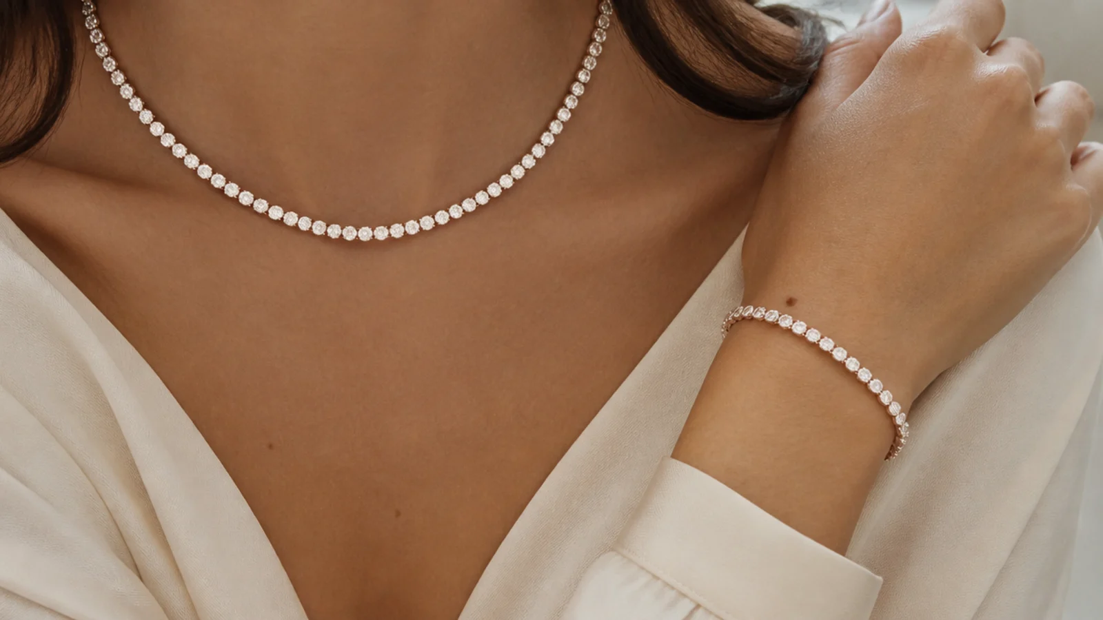 Faceless close-up of a lab-grown white stone riviere necklace and matching tennis bracelet