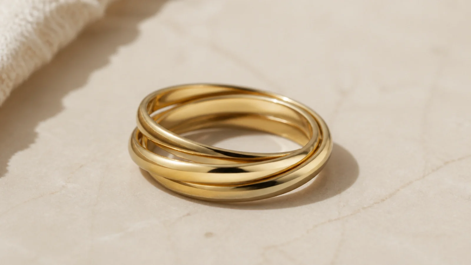 Faceless close-up of multiple connected gold band rings that move together as one linked ring