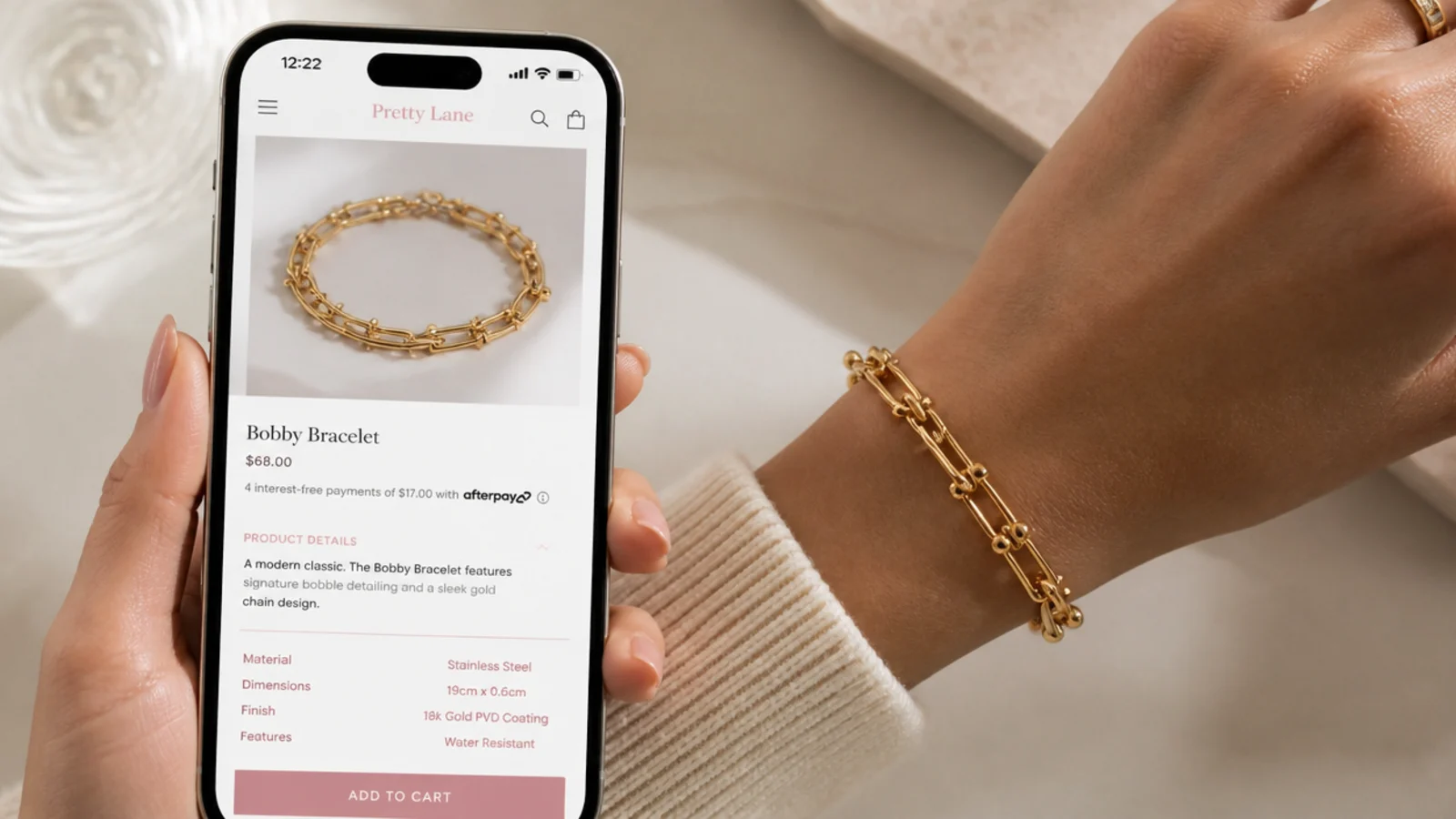Faceless phone screen capturing a jewelry listing with material and dimensions highlighted