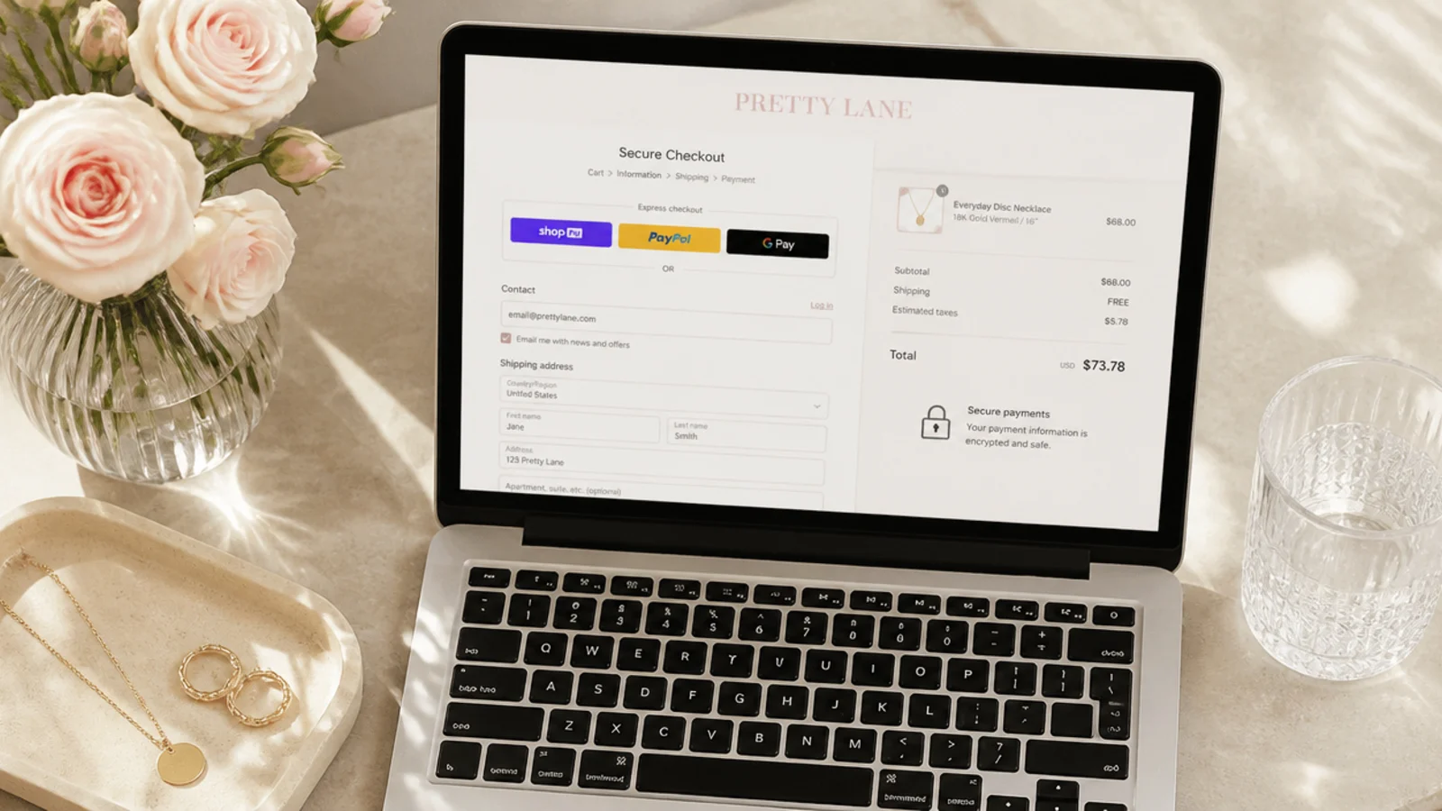 Faceless overhead shot of a laptop checkout page for a gold necklace with a secure payment icon