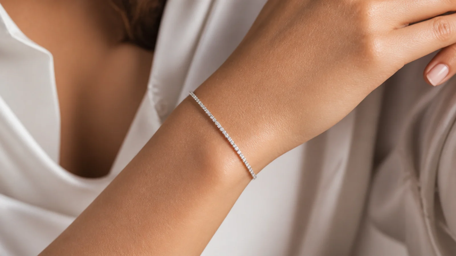 Faceless close-up of a thin diamond tennis bracelet on the wrist catching the light