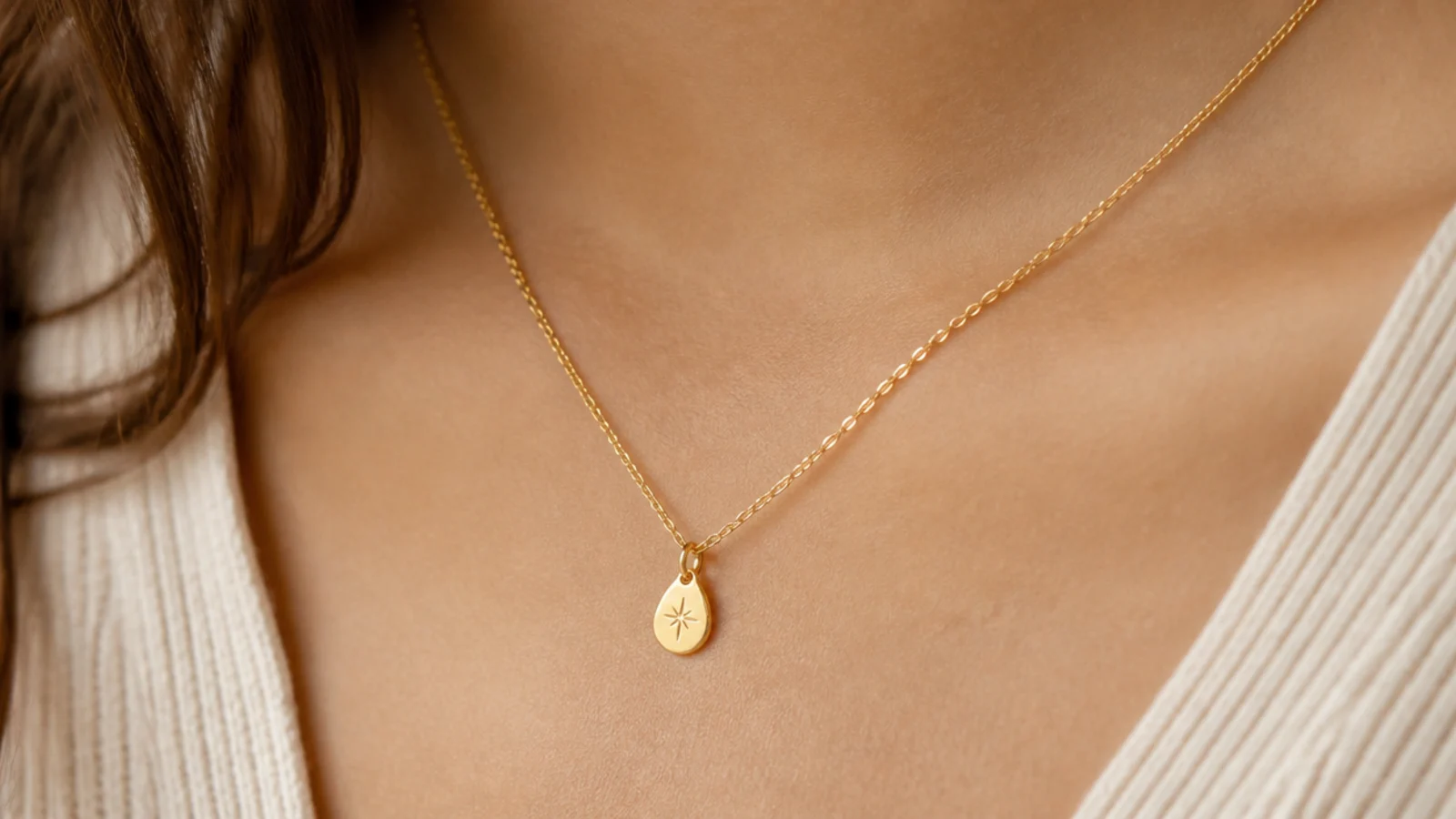 Faceless close-up of a dainty gold vermeil pendant necklace on the collarbone, an affordable tarnish-resistant pick