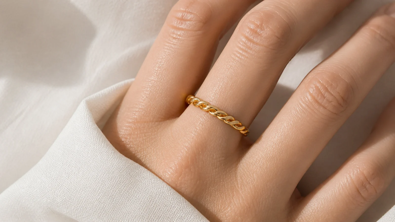 Faceless close-up of a waterproof gold PVD stainless steel ring on a finger, a tarnish-proof pick under fifty dollars