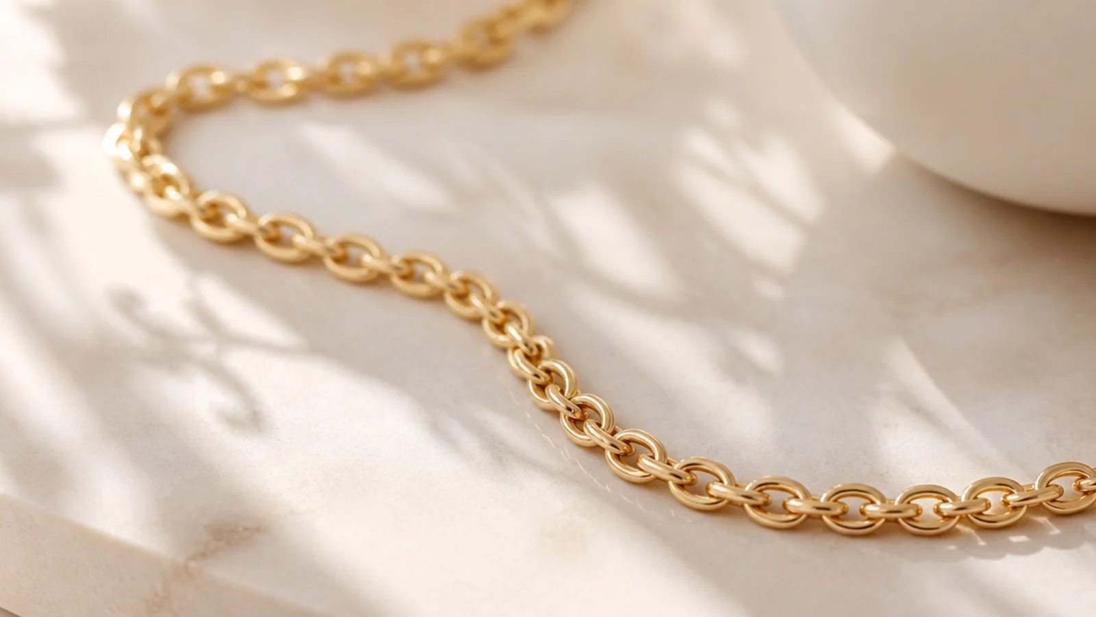 Faceless macro of a gold-filled chain showing a thick bonded 14k layer over a brass core