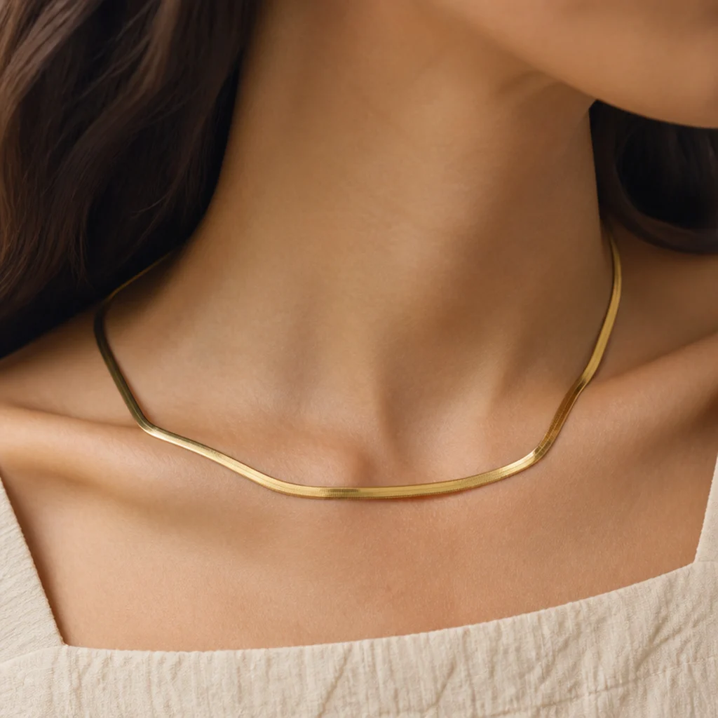 Faceless close-up of a straight gold collar necklace echoing a square neckline