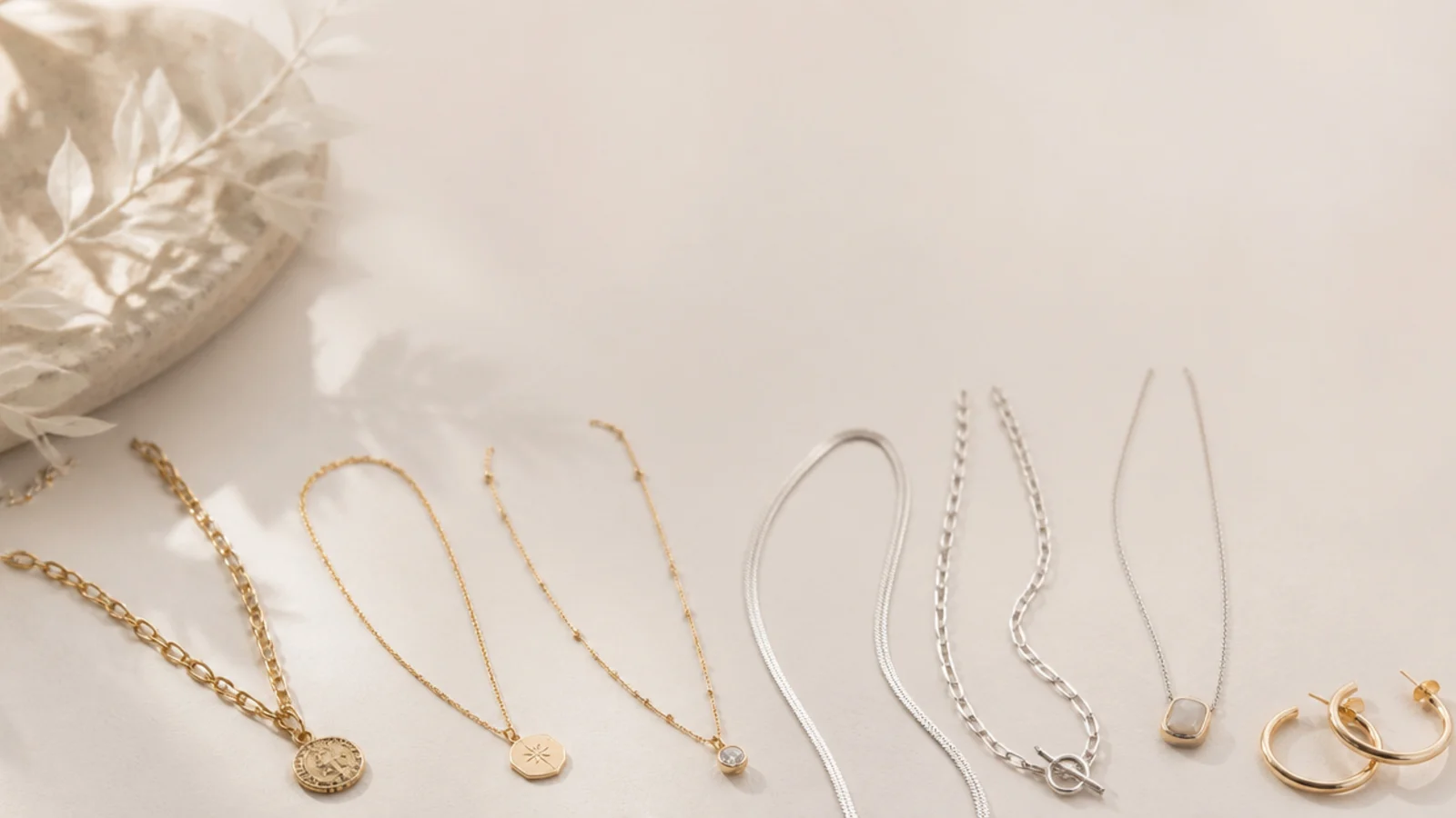 Faceless flat-lay of gold and silver jewelry sorted by neckline for styling any outfit