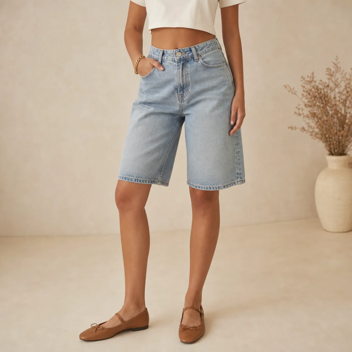 Faceless waist-down shot of denim jorts with a cropped tee and ballet flats