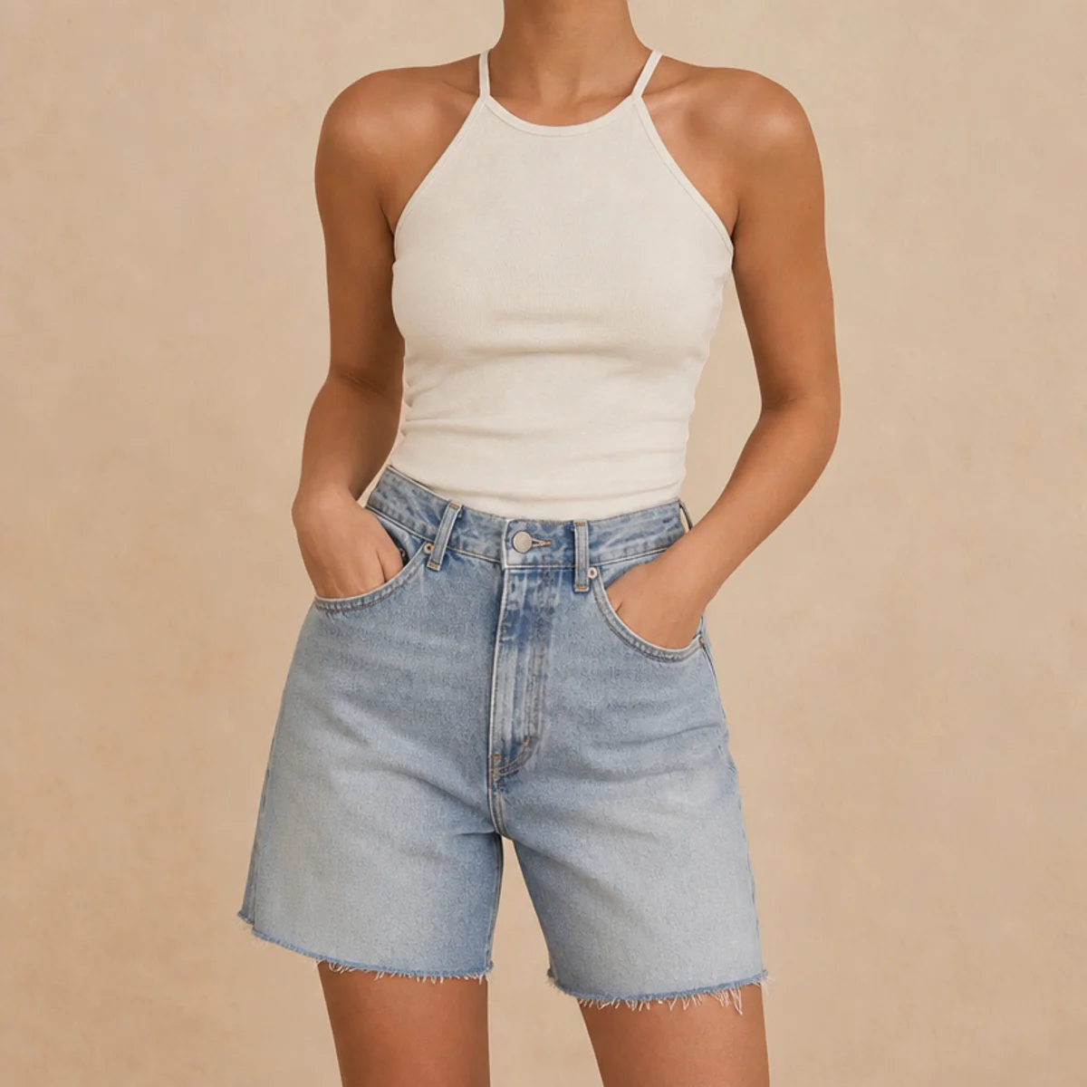 Faceless waist-up shot of a halter-neck tank with high-waisted denim jorts