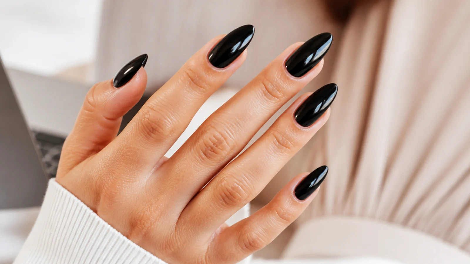 Long glossy black almond nails with a sharp taper and mirror-like shine