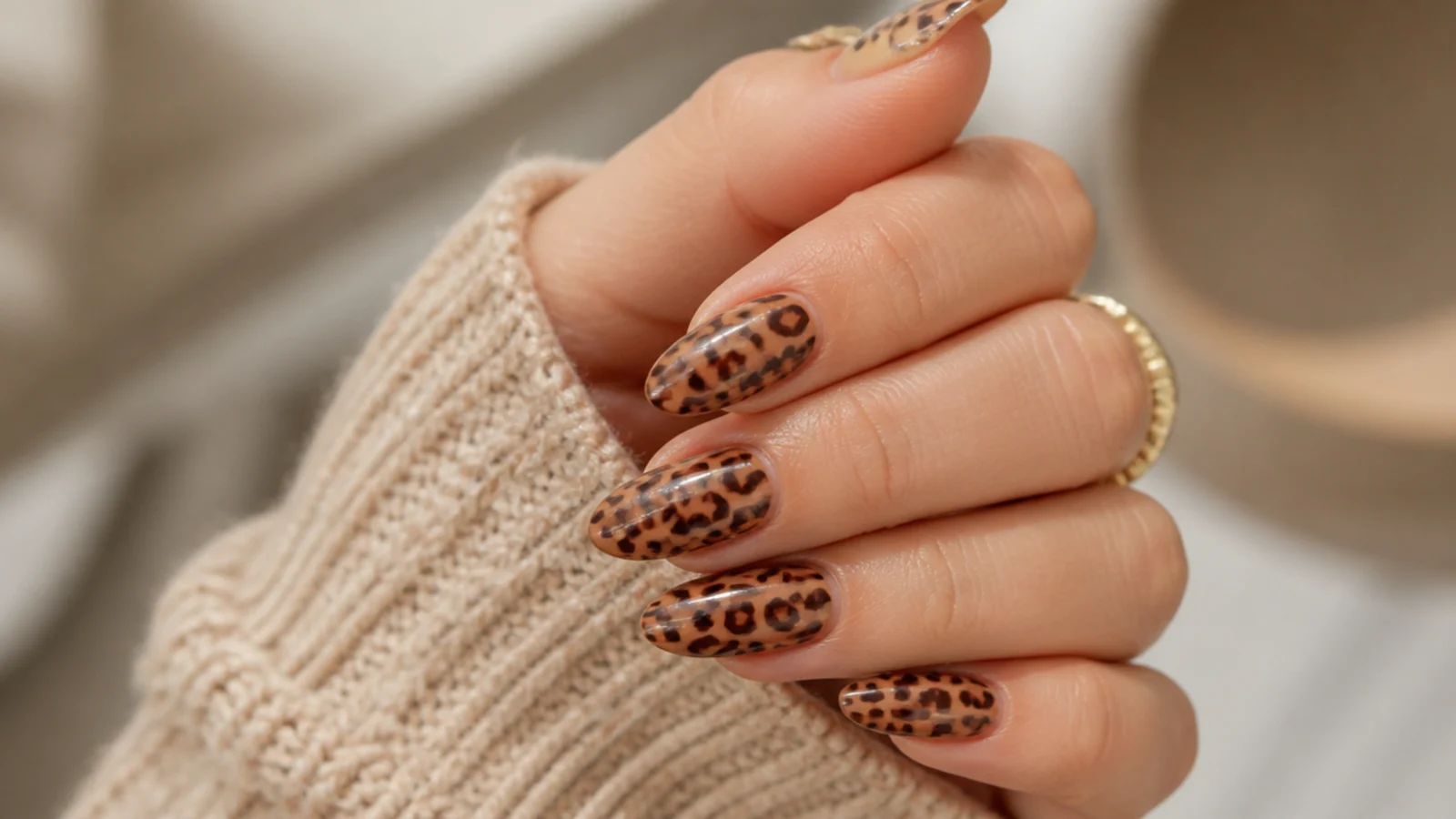 Medium almond nails with brown and black leopard print spots on a caramel base