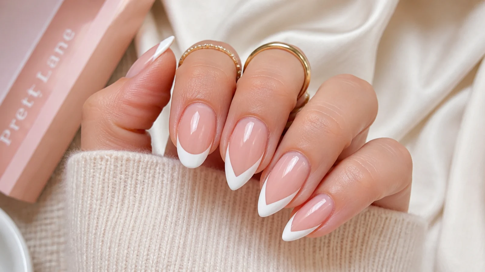 Oval nails with a curved French tip beside almond nails with a V shaped French tip