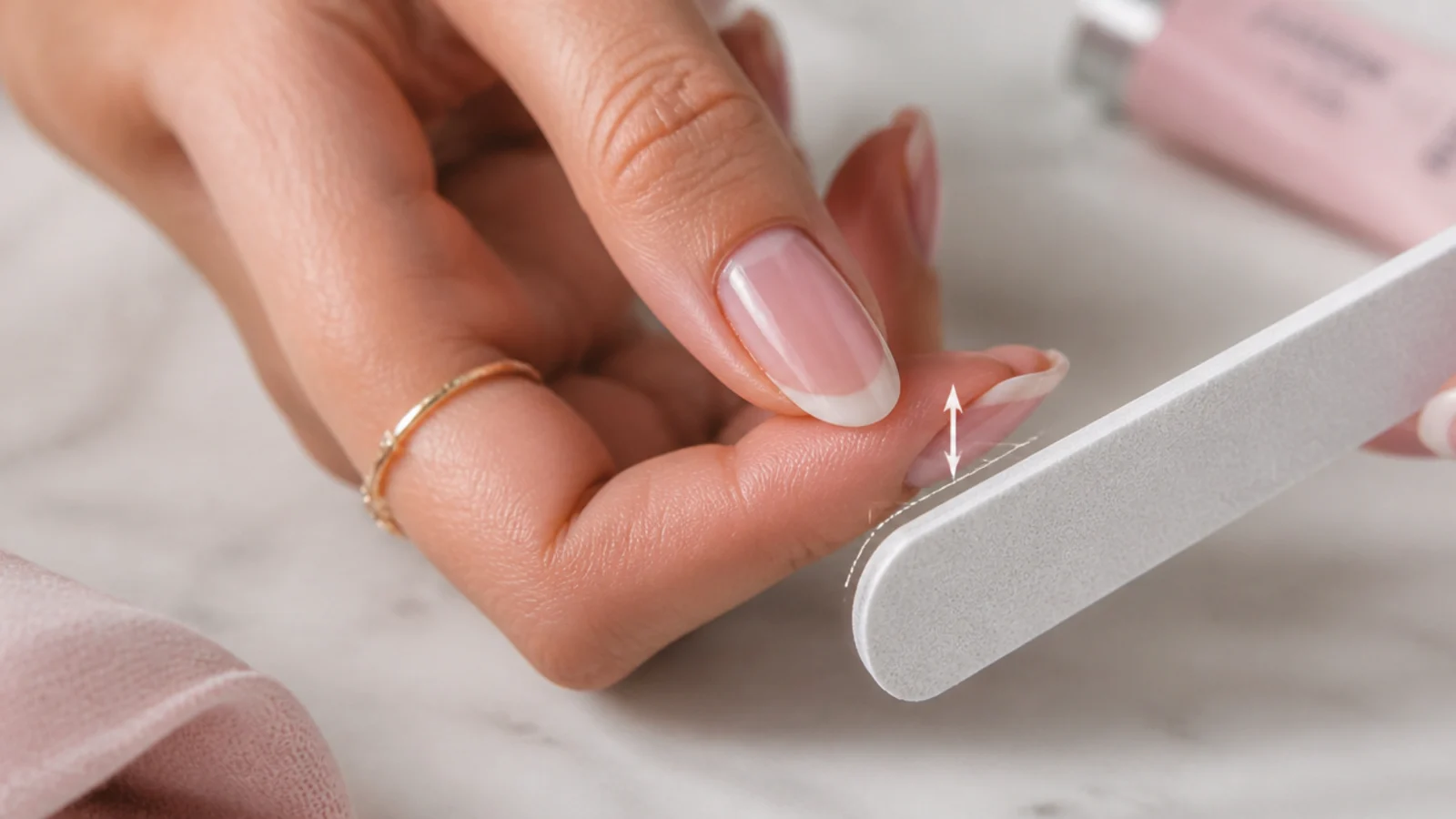 Almond nail being refiled into an oval shape showing the length lost at the tip