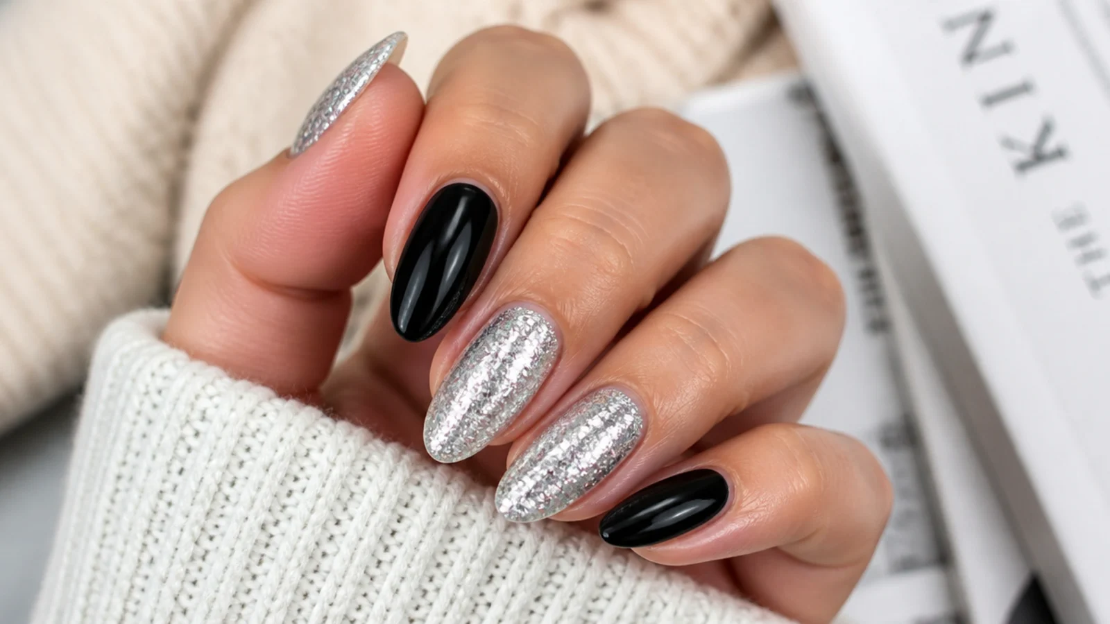 Black and silver almond nails with two glossy black nails and three silver glitter accent nails
