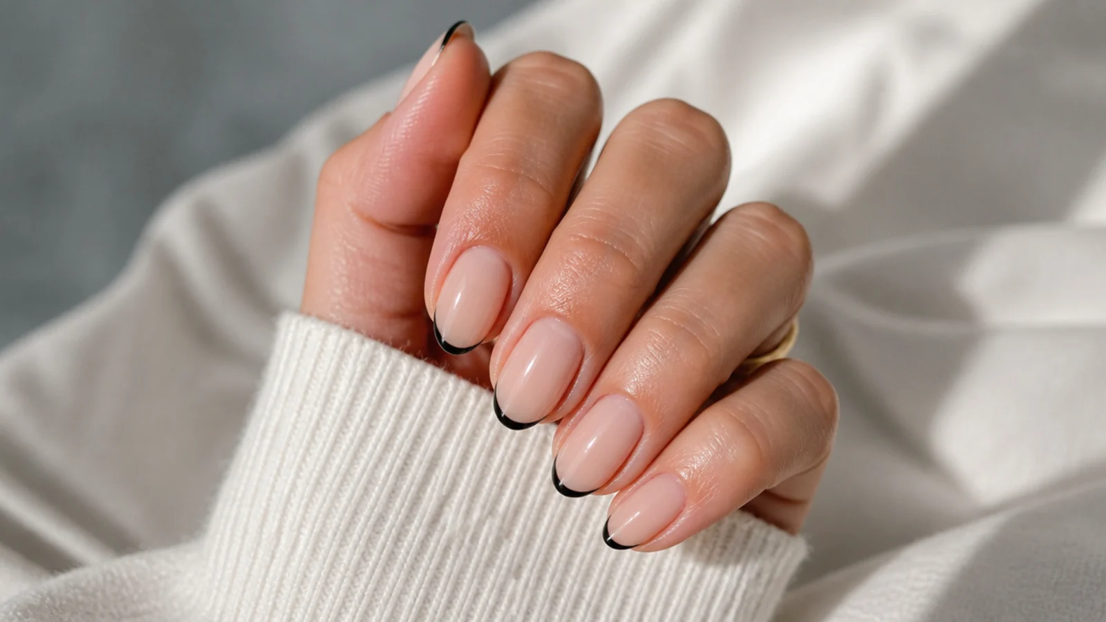 Short almond nails with a hairline black micro French tip on a bare natural nail