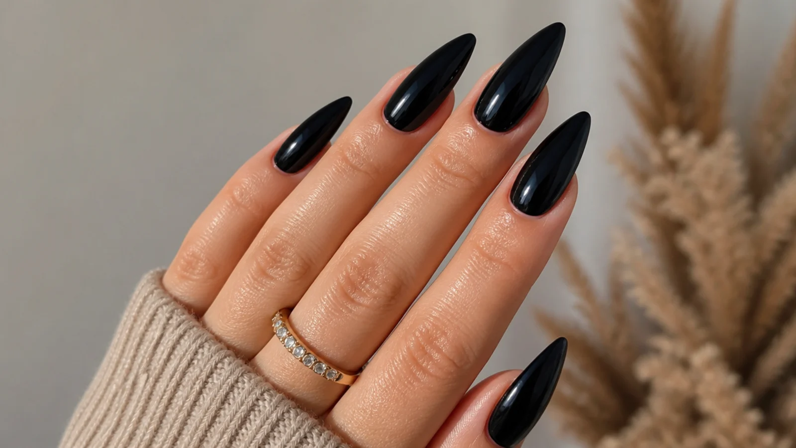 Long glossy black almond nails on extensions with a dramatic tapered point