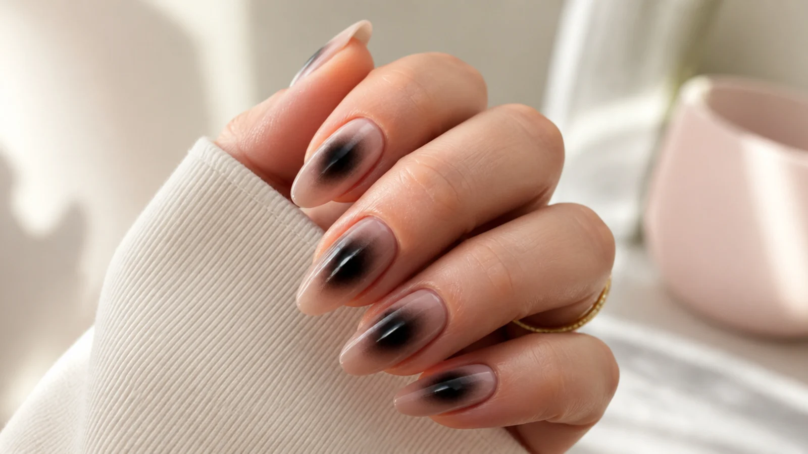 Almond nails with a soft black aura haze airbrushed into the center of a sheer nude base