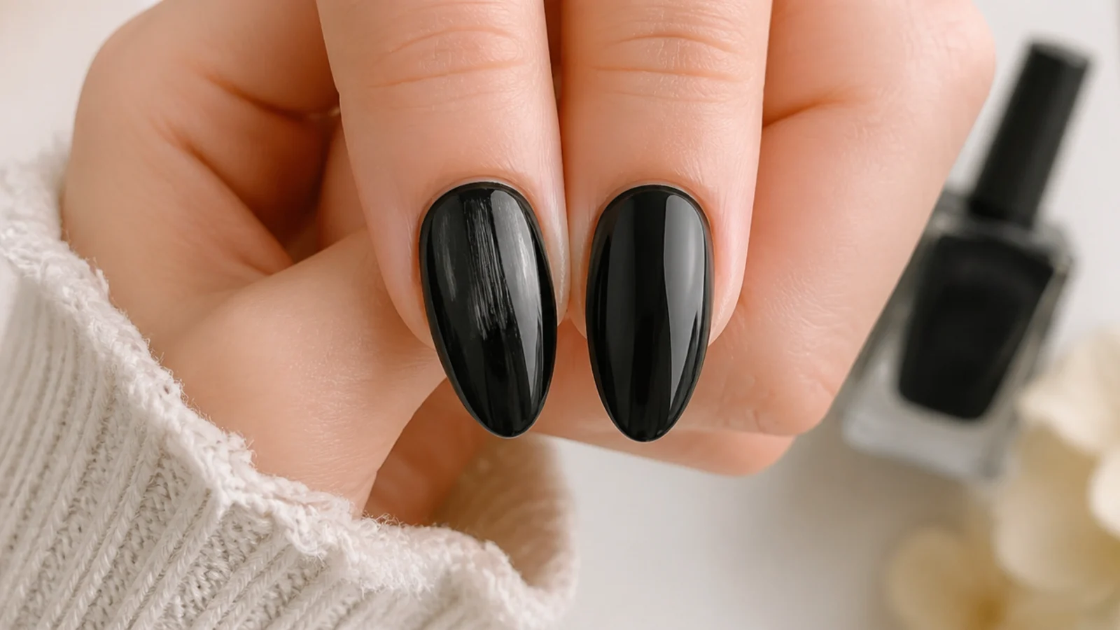 Two black almond nails compared, one streaky and uneven and one smooth and evenly covered