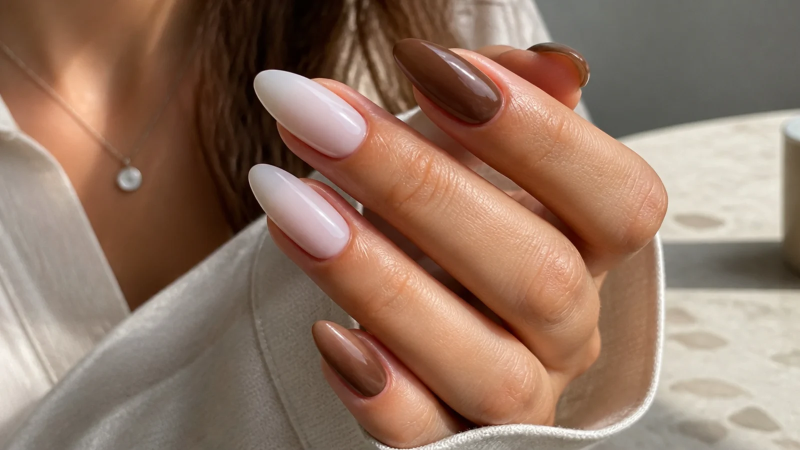 Long oval nails in milky white beside long almond nails in mocha brown showing both tip shapes