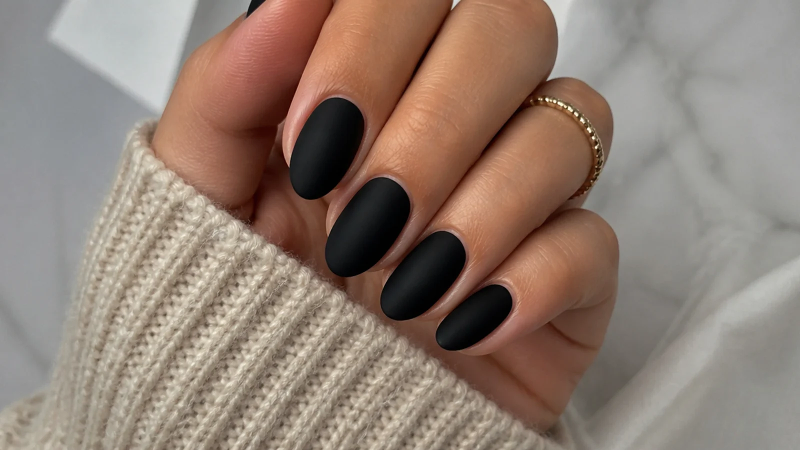 Short almond nails in flat matte black with sharply tapered sidewalls