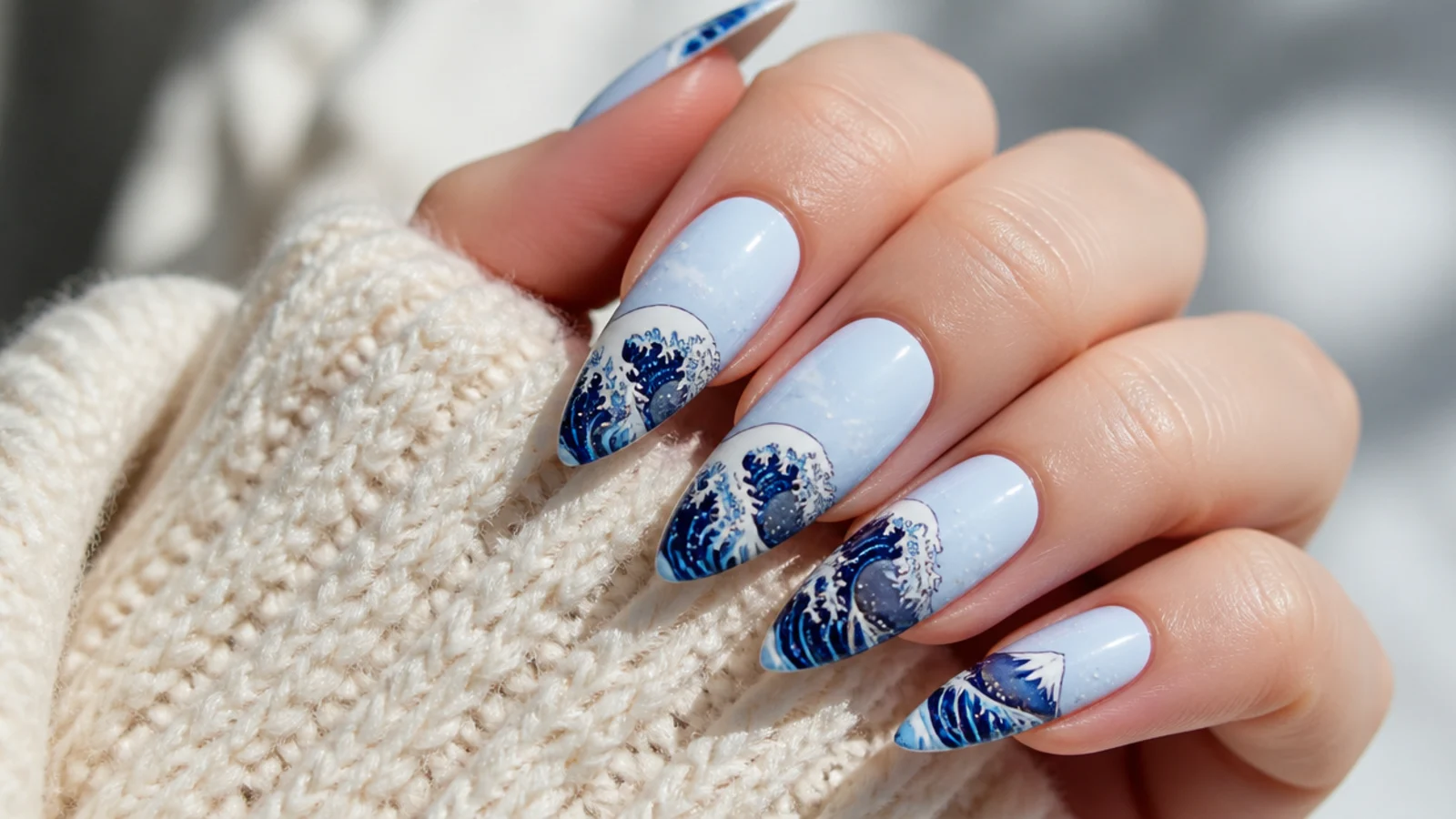 Long blue nails with a hand-painted Japanese great wave and white foam claws over a pale sky base