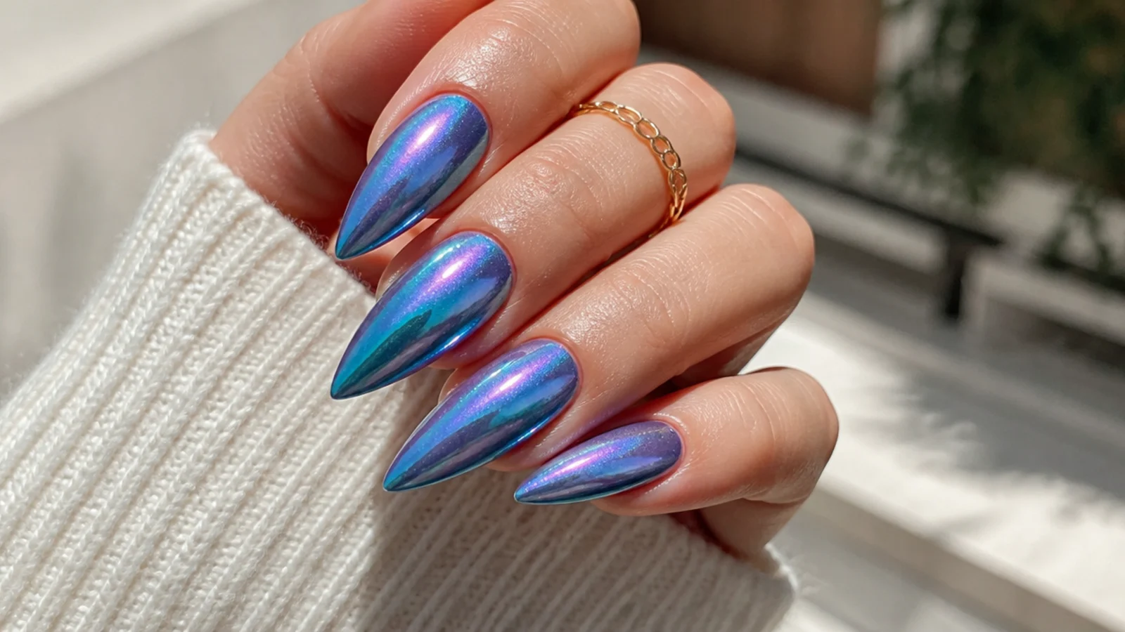 Long nails with iridescent blue-green mermaid chrome shifting between teal and violet in the light