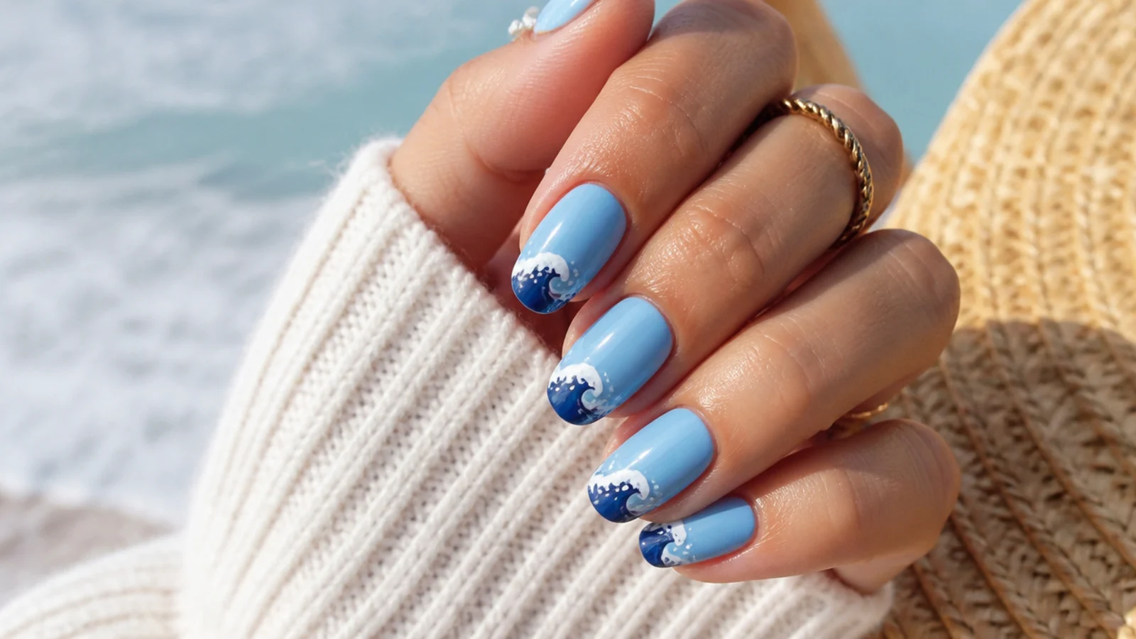 Medium length blue summer nails with a white foam ocean wave curling across a navy tip