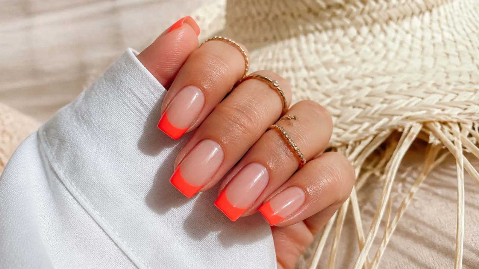 Medium square neon coral French tip summer nails on a sheer nude base