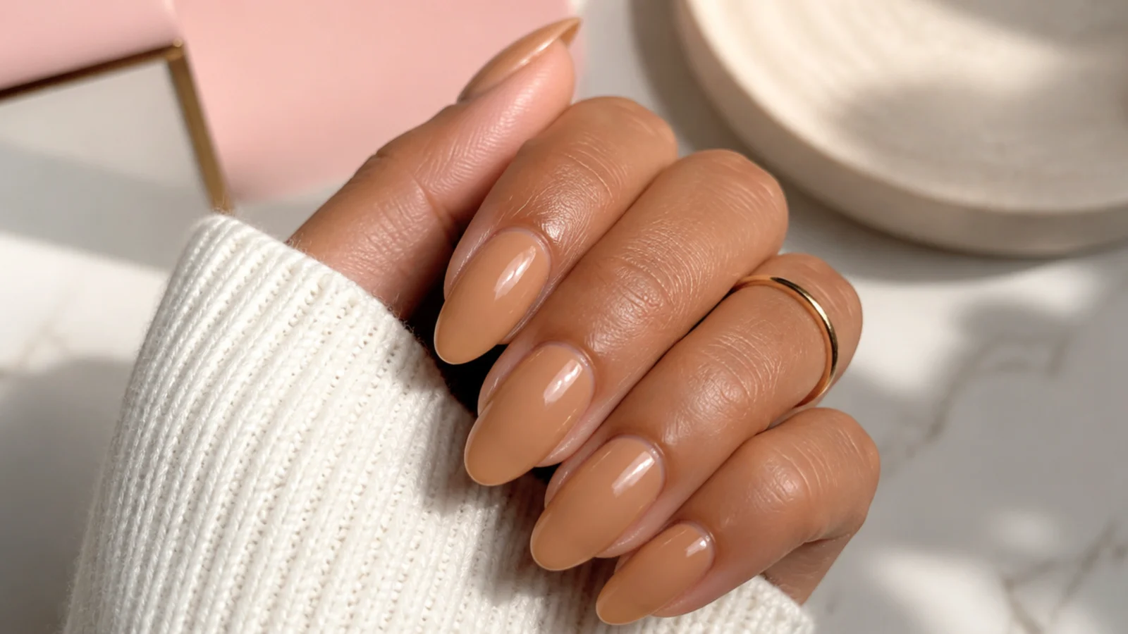Golden caramel nude nails on a tanned hand in a warm your-nails-but-better tone