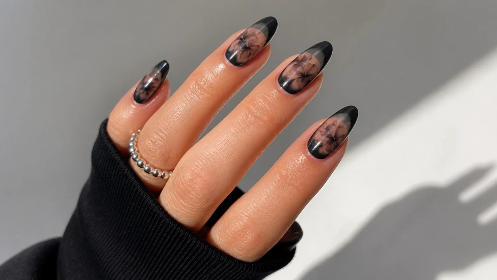 Black blooming gel nails with clear negative space and diffused black edges