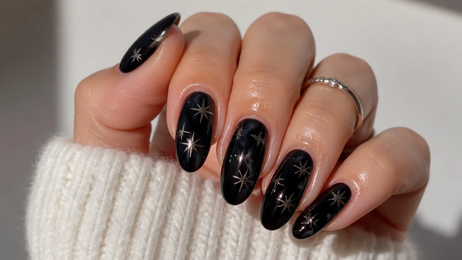 Cuticle oil applied around long-lasting black blooming gel nails