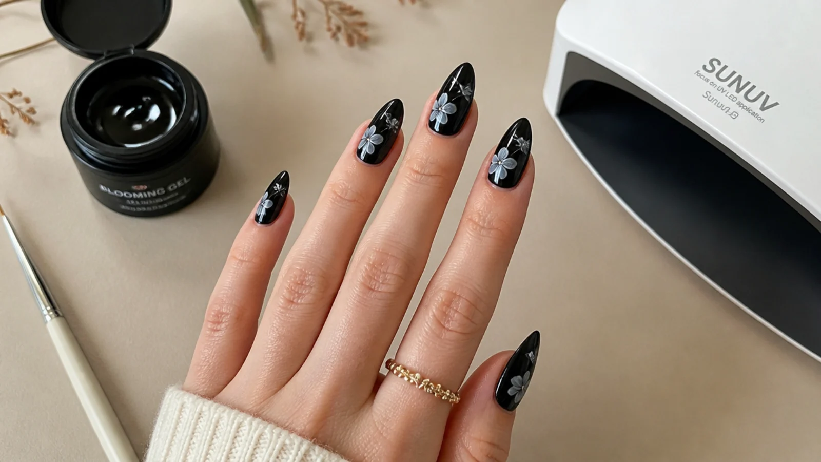 Flat lay of blooming gel, black gel polish, lamp and detail brush