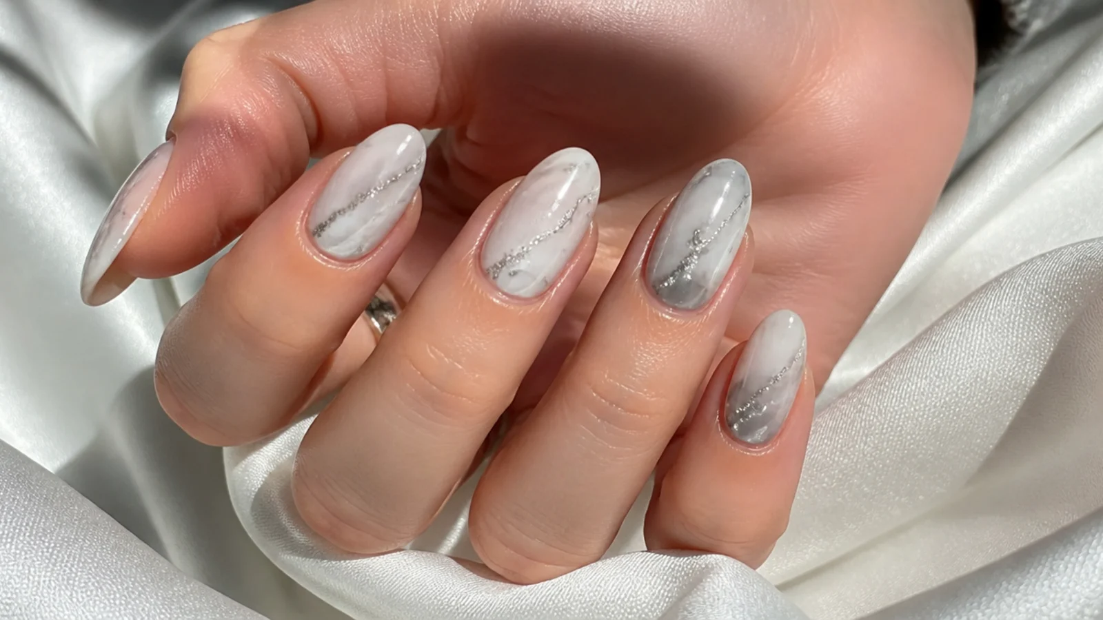 Soft gray and silver cloudy blooming gel nails on a white base