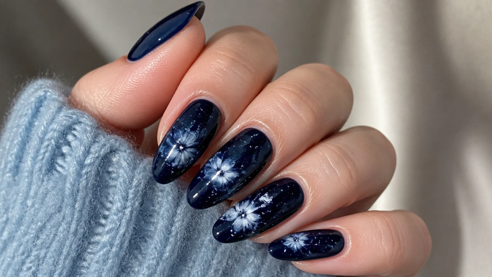 Deep navy blooming gel nails with tiny white snow dots