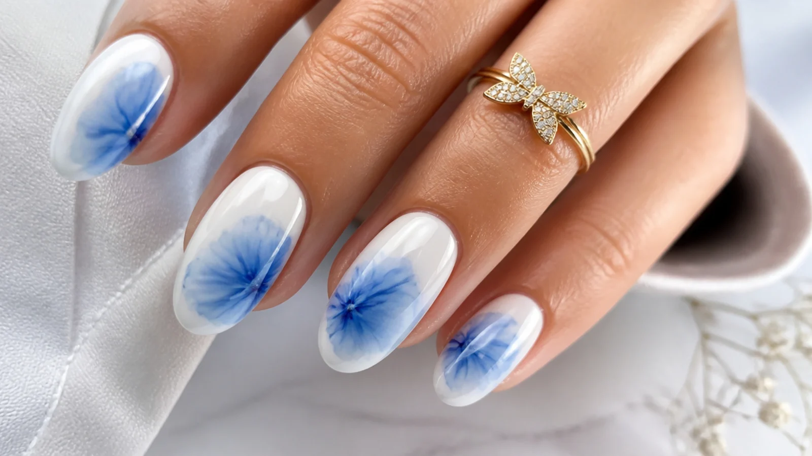 Abstract blue tie-dye bloom feathering across a white nail