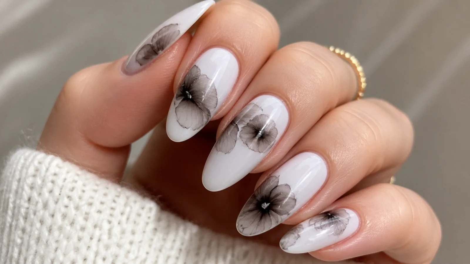 Diffused black and gray orchid feathered across a white nail