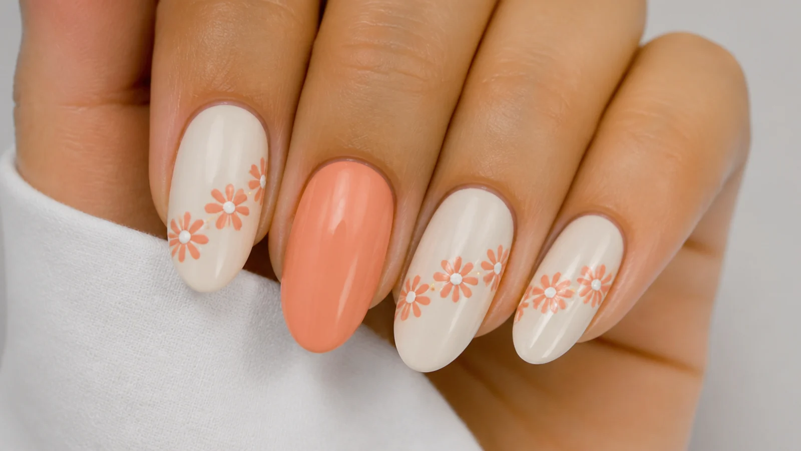 Row of diffused coral daisies with white centers across a cream nail