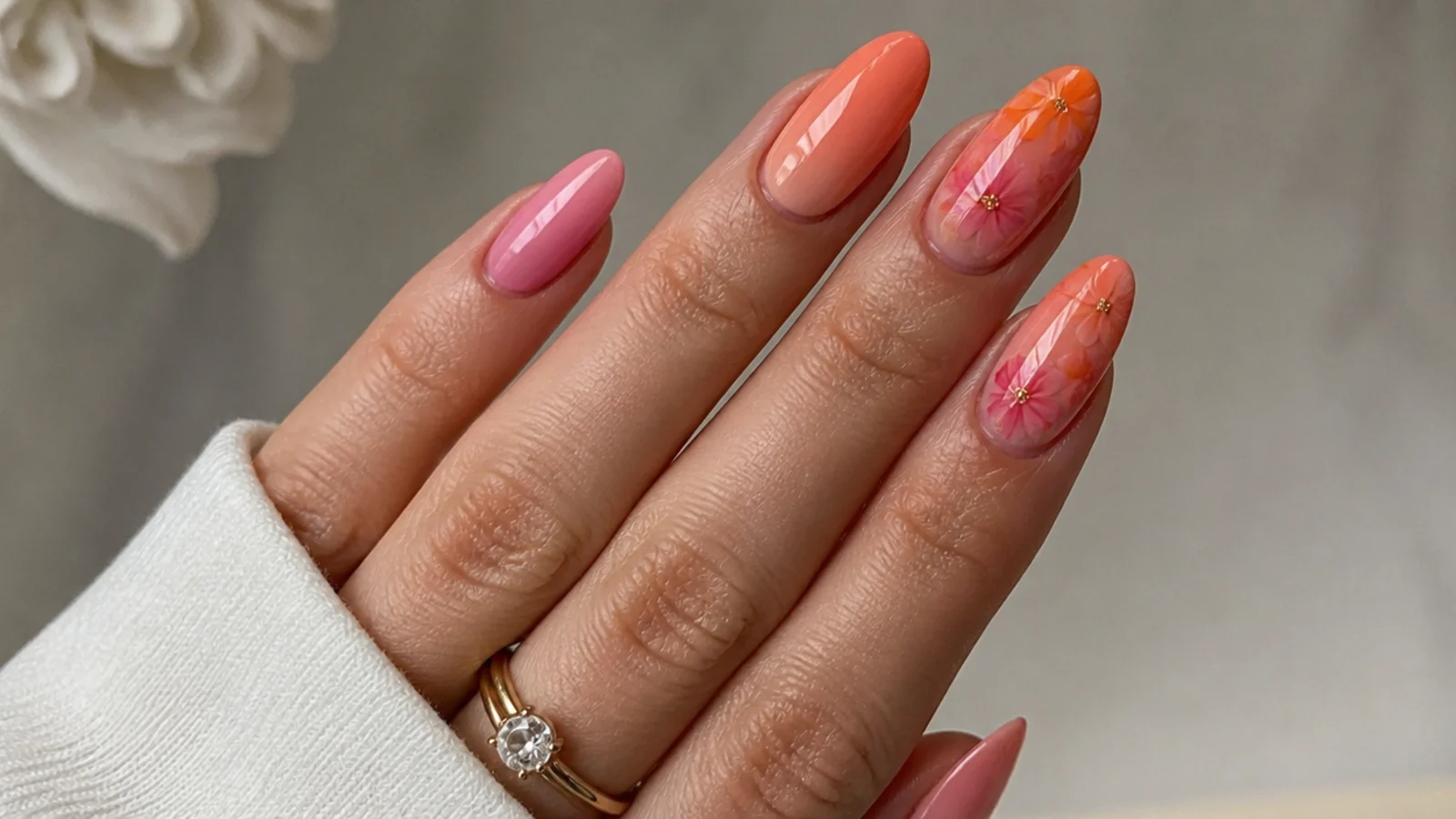 Warm sunset orange, pink and coral blooming gel nails blending together