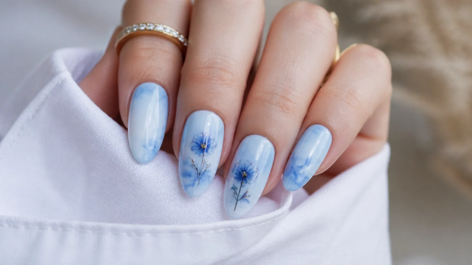 Blue blooming gel nails with a soft sky-blue and white marble pattern