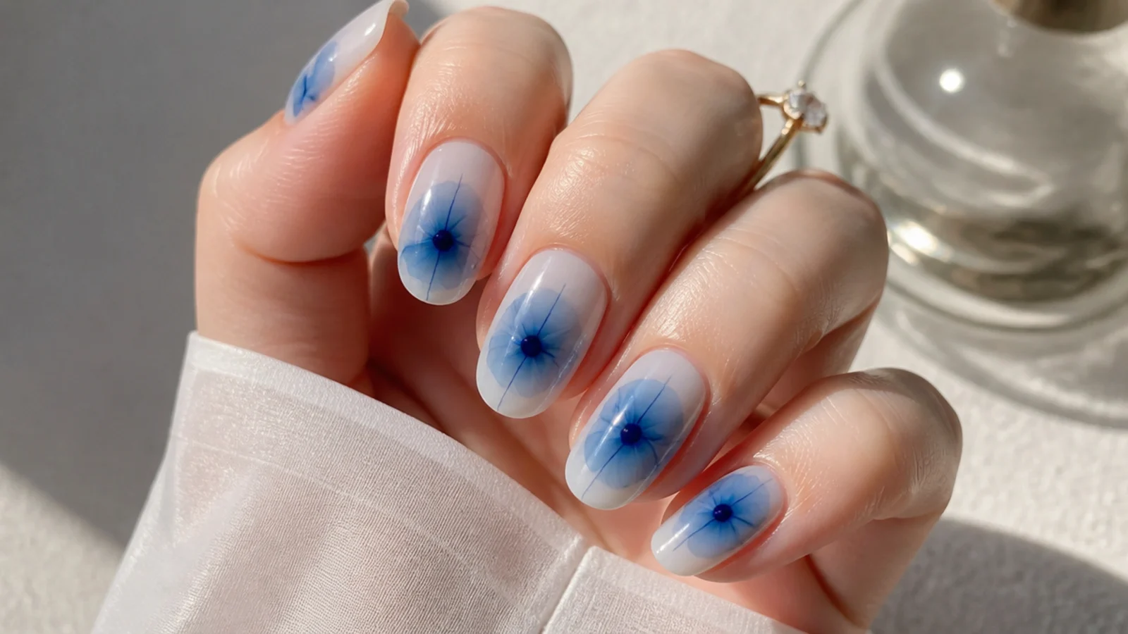 Blue blooming gel nails with single navy ink drops blooming outward