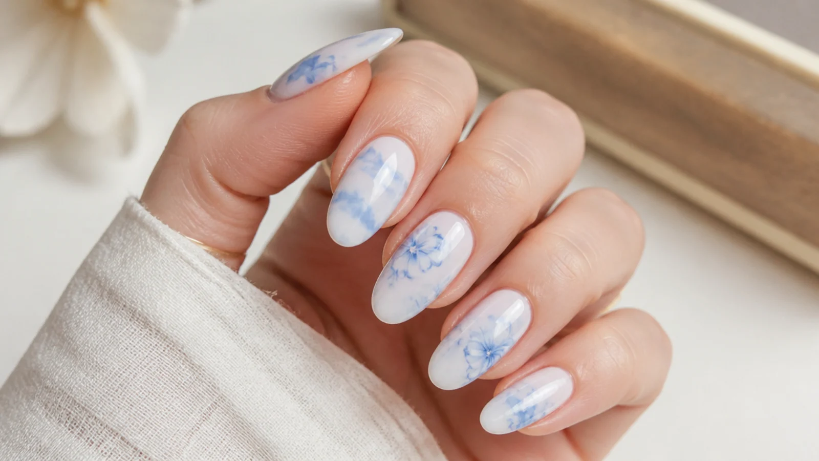 Blue blooming gel nails with soft powder-blue clouds over a milky base