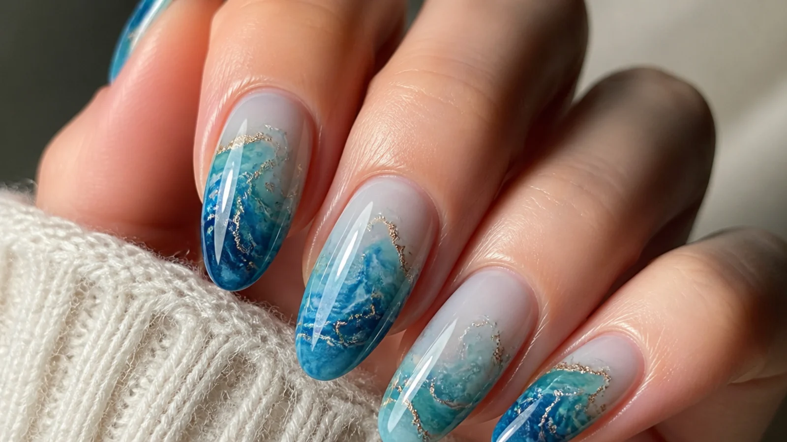 Blue blooming gel nails with teal and blue ocean-water marble
