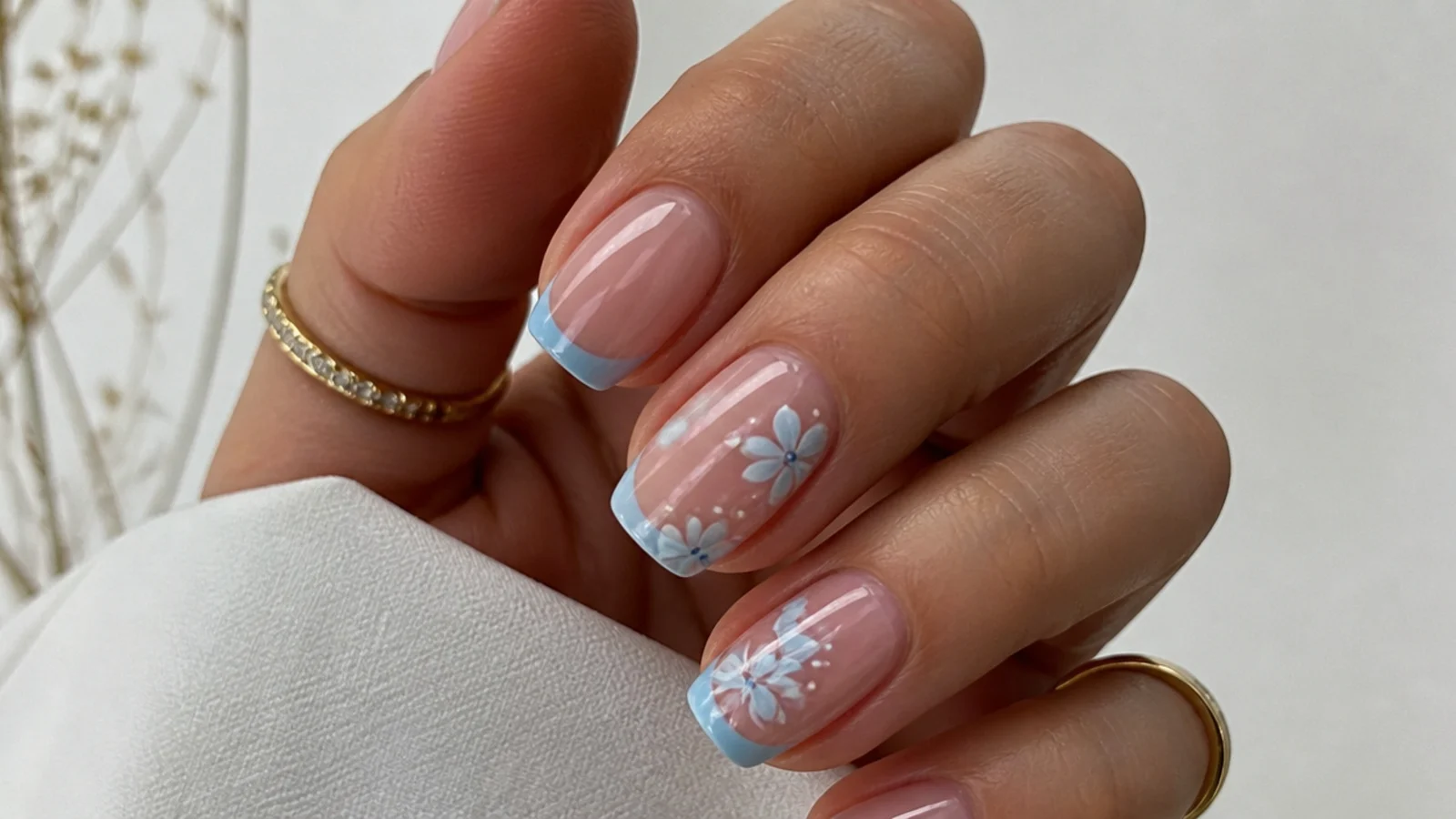 Blue blooming gel nails with a soft-edged baby blue French tip