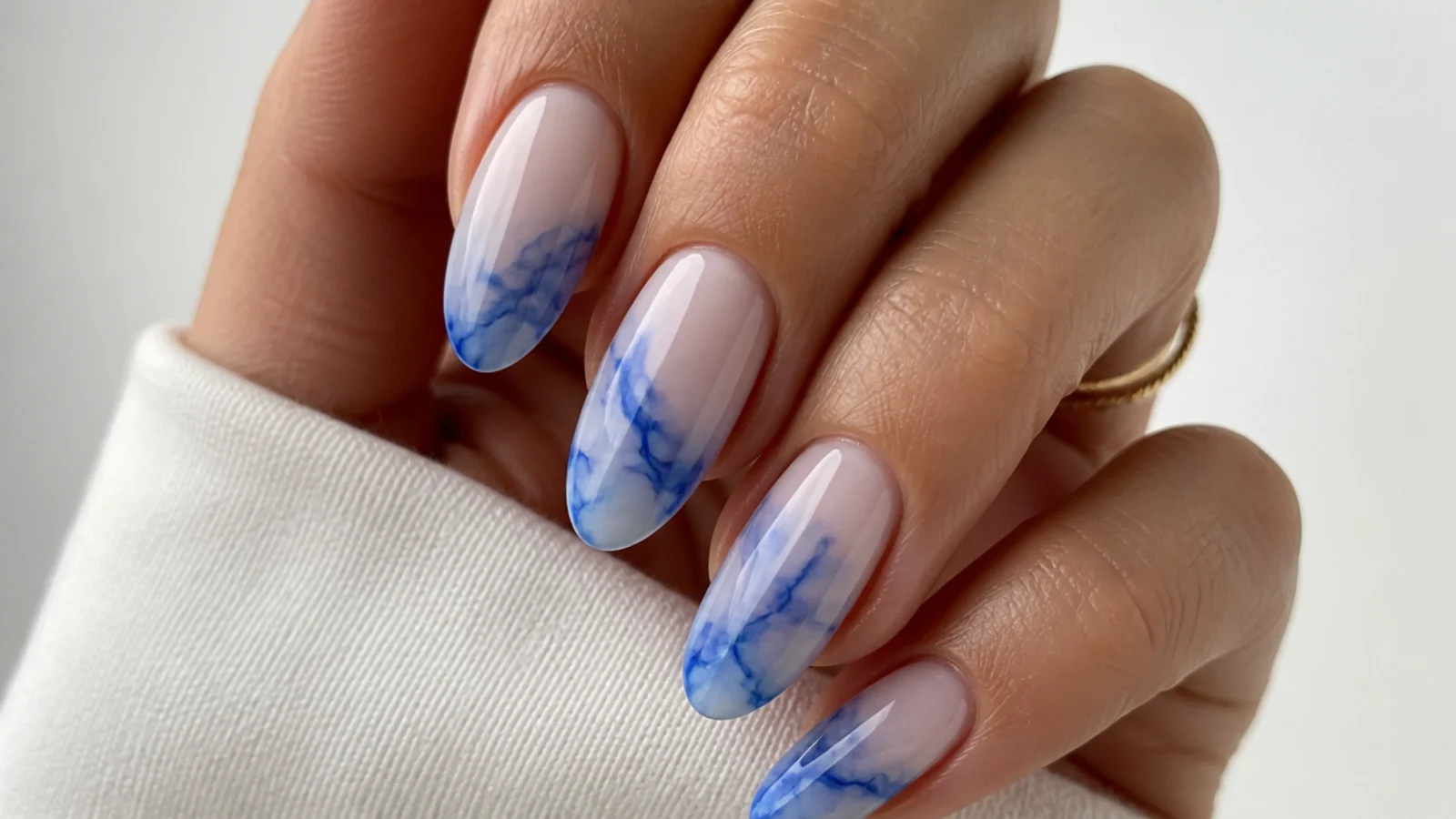 Blue blooming gel nails with a wispy royal blue smoke effect