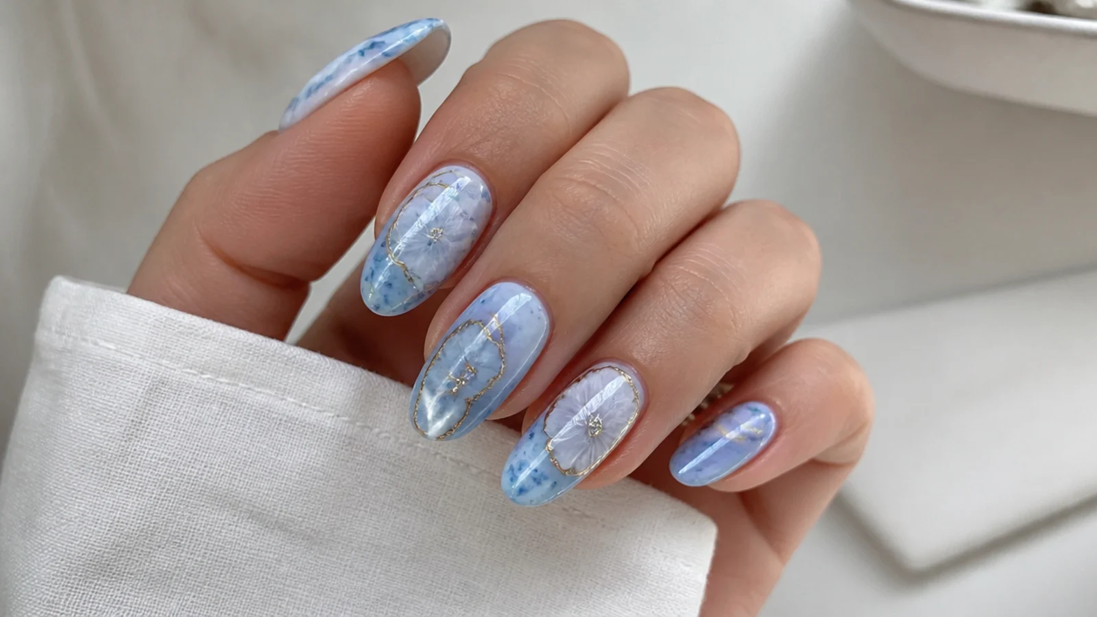 Blue blooming gel nails with an icy pale blue frosted marble