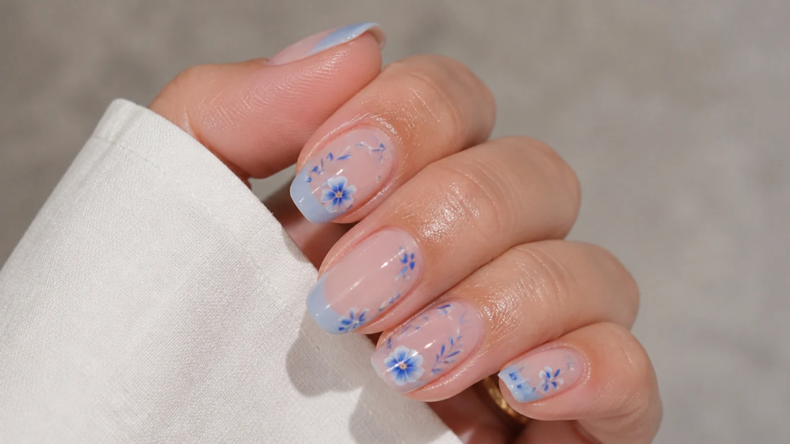 Well-kept blue blooming gel nails with cuticle oil applied