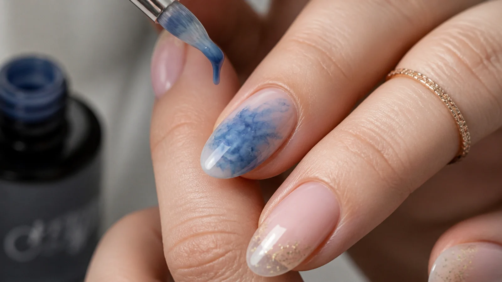 Blue gel color being dropped onto an uncured blooming gel layer